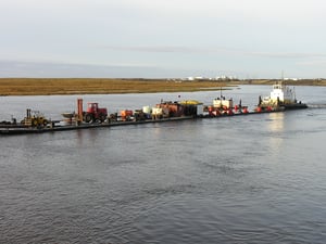The Toolik departing Bethel heading up river with their barges.
